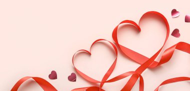 Hearts made of red ribbon on beige background with space for text. Valentine's Day celebration