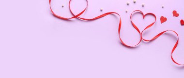 Heart made of red ribbon on lilac background with space for text. Valentine's Day celebration