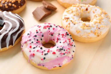 Wooden board of delicious donuts, closeup