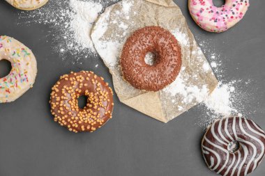 Delicious donuts and sugar powder on dark background