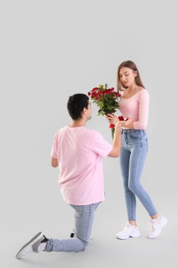 Young couple in love on light background. Valentine's Day celebration