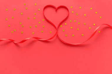 Heart made of ribbon on red background. Valentine's Day celebration