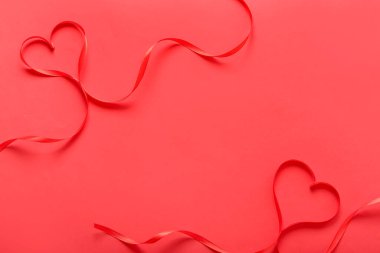 Frame made of ribbons on red background. Valentine's Day celebration