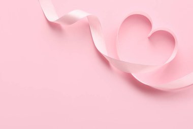 Heart made of ribbon on pink background. Valentine's Day celebration