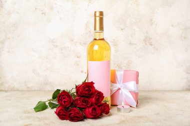 Kırmızı güller, bir şişe şarap, arka planda hediye ve mum. Sevgililer Günü kutlaması