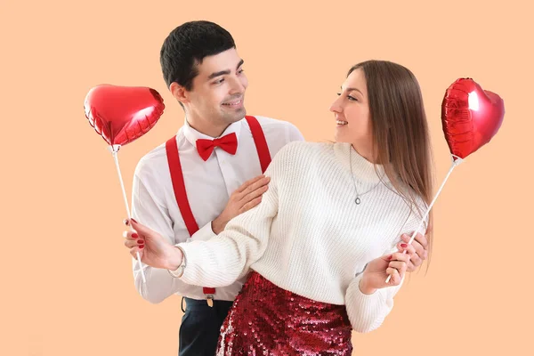 一对年轻夫妇爱上了米色背景的气球 情人节庆祝活动 — 图库照片