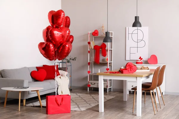 Interior of dining room decorated for Valentine\'s Day with table, sofa and balloons