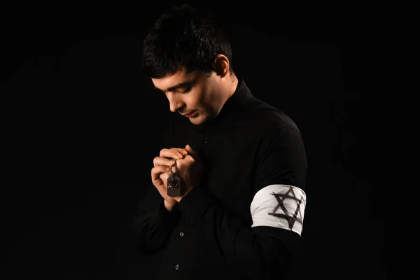 Praying Jewish man on dark background. International Holocaust Remembrance Day