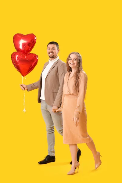 Happy Young Couple Heart Shaped Balloons Yellow Background Valentine Day — Fotografia de Stock