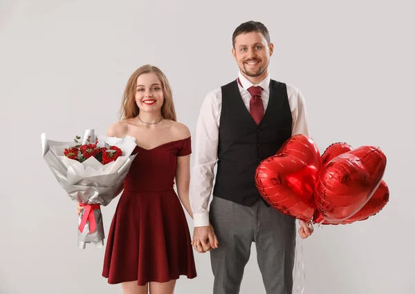 Jovem Casal Feliz Com Balões Forma Coração Flores Fundo Claro — Fotografia de Stock