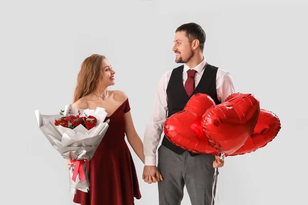 Jovem Casal Feliz Com Balões Forma Coração Flores Fundo Claro — Fotografia de Stock