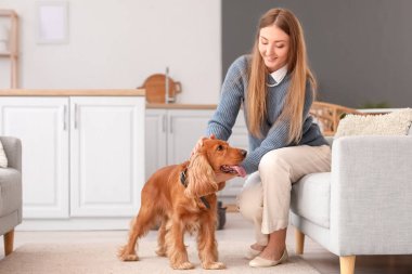 Young woman with red cocker spaniel in kitchen