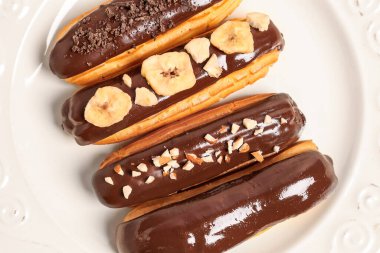 Plate of delicious chocolate eclairs, closeup
