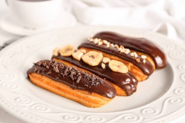 Plate of delicious chocolate eclairs, closeup