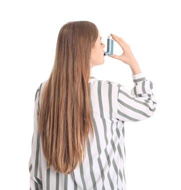 Sick young woman with inhaler on white background