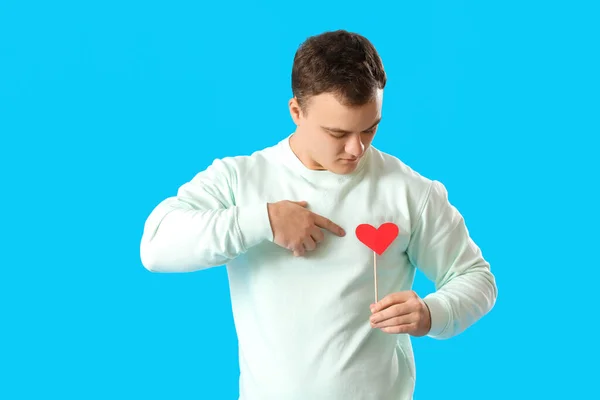 Nuori Mies Osoittaa Paperia Sydämeen Ystävänpäivä Sinisellä Taustalla — kuvapankkivalokuva