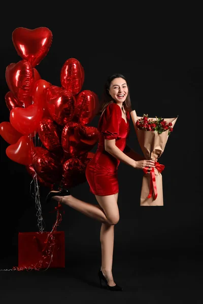 Beautiful woman with roses and balloons on black background. Valentine\'s Day celebration