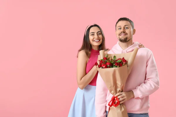 Happy couple in love with roses on pink background. Valentine\'s Day celebration
