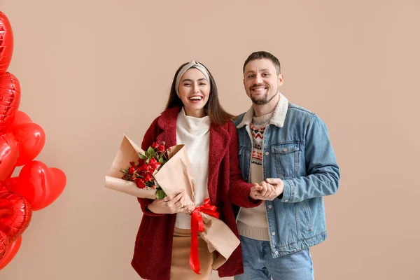 Happy couple in love with roses on beige background. Valentine's Day celebration