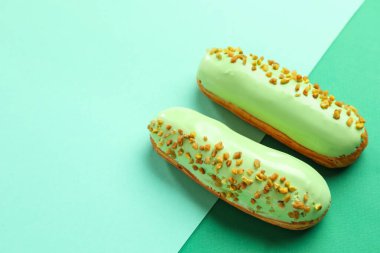 Delicious pistachio eclairs on green background