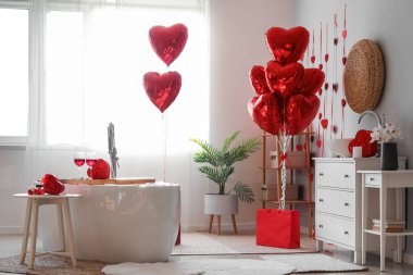 Interior of bathroom decorated for Valentine's Day with heart-shaped balloons and gifts
