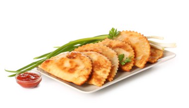 Plate with tasty chebureks, sauce and onion on white background