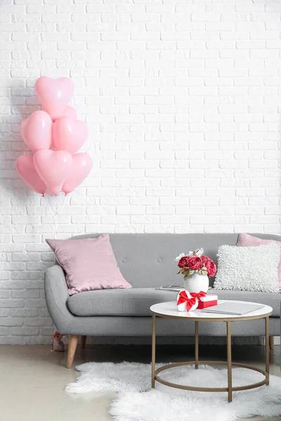 Interior of living room with sofa and pink balloons for Valentine\'s Day