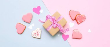 Composition with tasty heart shaped cookies and gift on color background. Valentine's Day celebration