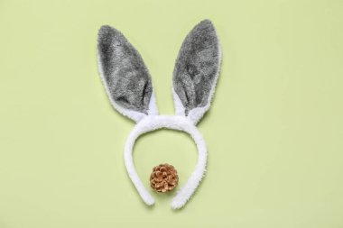 Bunny ears with fir cone on green background clipart