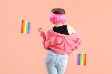Young woman with LGBT flags on pink background, back view