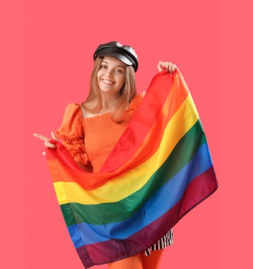 Beautiful young woman in hat with LGBT flag on red background