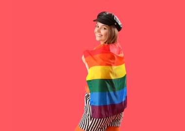 Beautiful young woman in hat with LGBT flag on red background