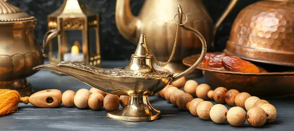 Aladdin lamp of wishes, dates and tasbih on wooden table