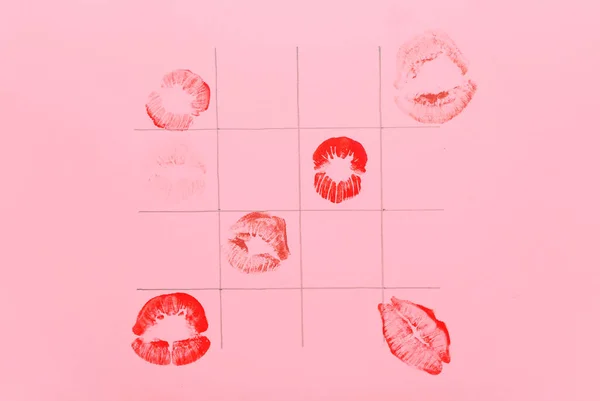 Lipstick kiss marks and drawn squares on pink background