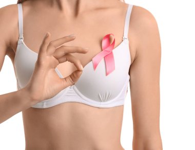 Young woman in underwear with pink ribbon showing OK on white background. Breast cancer awareness concept