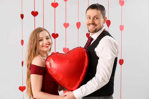 Happy Young Couple Heart Shaped Balloon Light Background Valentine Day — Stock Photo, Image