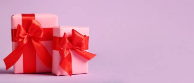 Gift boxes for Valentine's Day on lilac background with space for text