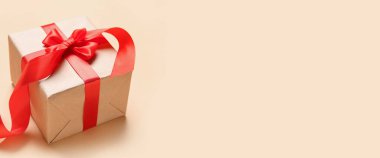 Gift box on beige background with space for text. Valentine's Day celebration