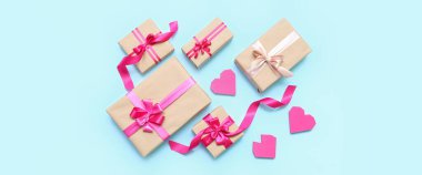 Composition with beautiful gift boxes and hearts on light blue background. Valentine's Day celebration