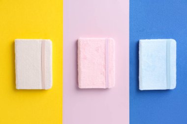 Stylish notebooks on colorful background