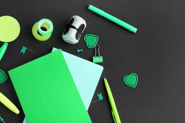 Composition with green stationery on dark background