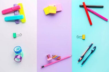 Frame made of colorful stationery on color background