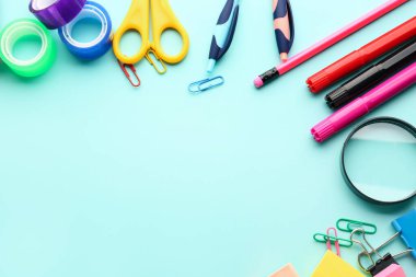 Set of stationery with magnifier on color background