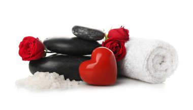 Spa stones with sea salt, towel, heart and roses on white background. Valentine's Day celebration