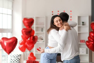 Engaged couple hugging at home on Valentine's Day