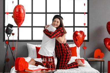 Young couple hugging in bedroom on Valentine's Day