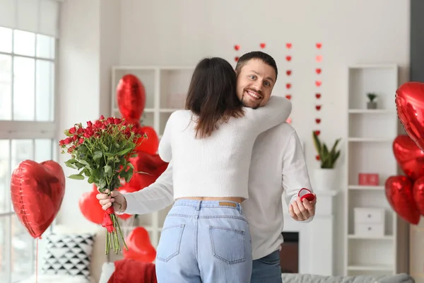 Engaged couple hugging at home on Valentine\'s Day