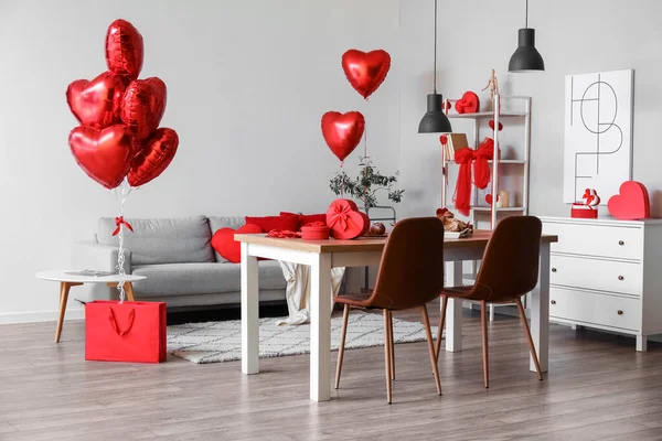 Interior of dining room decorated for Valentine\'s Day with table, sofa and balloons