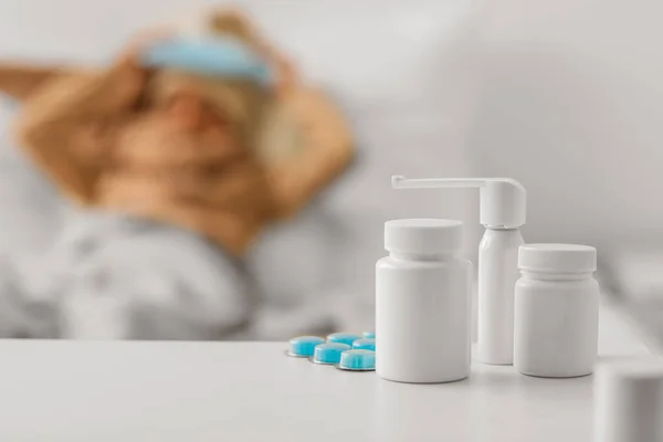Different medicines on table in bedroom of ill boy, closeup