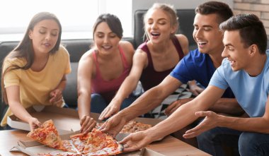 Friends taking slices of hot tasty pizza from cardboard box at home party